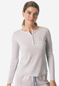 Grijs lang mouw henley-shirt in ribbelstructuur met een ronde halslijn en een zwarte knoopsluiting met vijf knopen, gekenmerkt door een klein geborduurd detail.