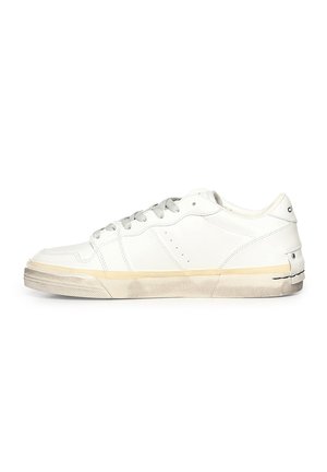 Zapatilla blanca de corte bajo con cordones grises, suela de goma con marcas de suciedad y detalles sutiles de costura sobre un fondo blanco.