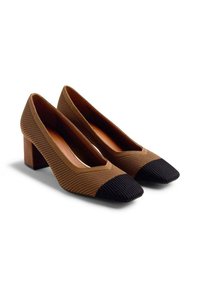 Escarpins en maille marron avec un talon bloc, arborant un capuchon de pointe noir à rainures et un design en V avec une découpe profonde sur les côtés.