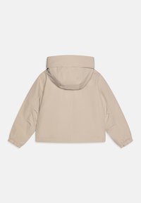 Beige hettejakke med lange ermer, elastiske mansjetter og en glatt, matt tekstur. Enkel design uten synlig maskinvare eller mønstre.