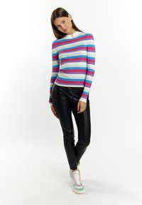 Ribota ilgomis rankovėmis viršūnė su daugiakolorėmis horizontaliomis juostelėmis rožinės, mėlynos ir baltos spalvų, derinama su juodomis dirbtinės odos kelnėmis ir pastelinių spalvų sportbačiais.