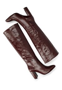 Bordeauxfarbene Lederstiefel über das Knie mit spitzer Zehe, blockiertem Absatz und seitlichem Reißverschluss. Glatte Textur mit dezentem Glanz.