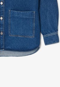 Denim shirt in a deep blue color. Features a button closure, long sleeves, and a single front pocket with orange stitching accents.