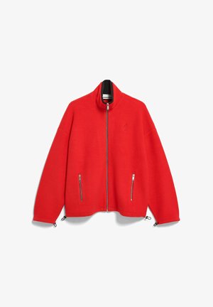 Rode jas van zachte stof, met een hoge kraag, een ritssluiting aan de voorkant en twee zijzakken met ritssluiting. Voorzien van verstelbare trekkoorden aan de zoom.