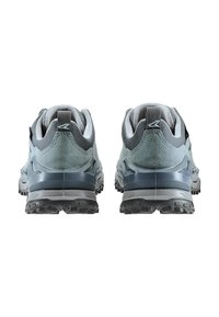 Un paio di scarpe da trekking grigio e nere viste da dietro, con suole robuste e collari imbottiti su uno sfondo bianco.