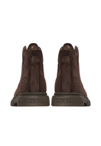 Ruske nilon ankle čizme prikazane sa stražnje strane s povlačnim trakom i teksturiranim tamnim gumiranim potplatima koji imaju zvjezdaste i tekstualne detalje.