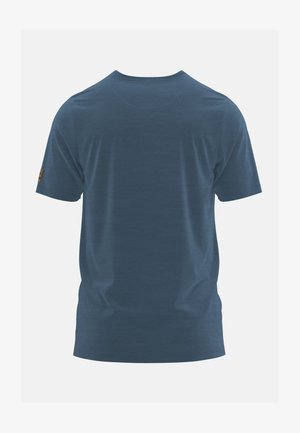 T-shirt a maniche corte di colore blu uniforme, vista da dietro con una piccola toppa marrone sulla manica sinistra, su sfondo grigio chiaro.