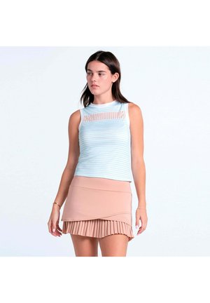 Frau trägt ärmelloses hellblau gestreiftes Oberteil mit transparentem Ausschnitt und beige mehrlagigen plissierten Minirock vor weißem Hintergrund.