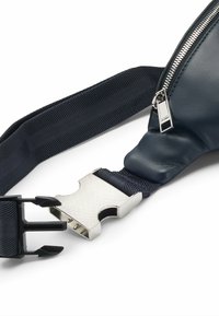 Borsa a tracolla in pelle blu navy con tracolla testurizzata, chiusura a zip e accessori in argento sulla fibbia, caratterizzata da un design liscio ed elegante.