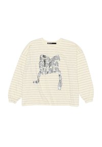 Camicetta a maniche lunghe color crema con sottili strisce orizzontali nere e un grande motivo a fiocco argento con il testo "Bimba Y Lola" sul davanti.