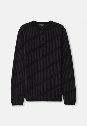 Pull-over henley noir à manches longues avec texture côtelée. Il présente trois boutons au col et un motif à rayures diagonales en noir plus foncé.