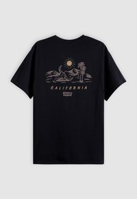 T-shirt noir avec un graphisme beige de montagnes, un palmier, le soleil et le texte "CALIFORNIA" avec un petit logo Levi's en dessous.