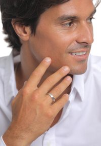 Sølvring med poleret finish båret på ringfingeren, mod en baggrund af lys hud og en del af en hvid skjorte.