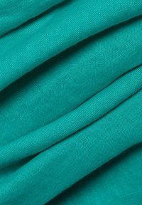 Azuurblauwe katoenen stof, gladde textuur en lichtgewicht met subtiele geweven patronen, gevouwen om lagen en diepte weer te geven.