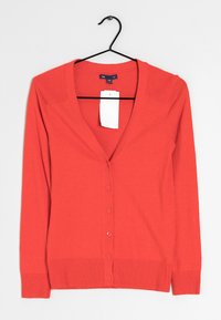 Röd kofta med djup V-ringning, långa ärmar och knäppning fram. Tillverkad av slätt tyg med ribbade muddar och nederkant. Inkluderar prislapp.