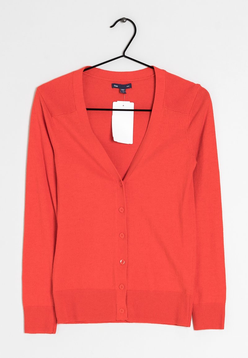 Röd kofta med djup V-ringning, långa ärmar och knäppning fram. Tillverkad av slätt tyg med ribbade muddar och nederkant. Inkluderar prislapp.