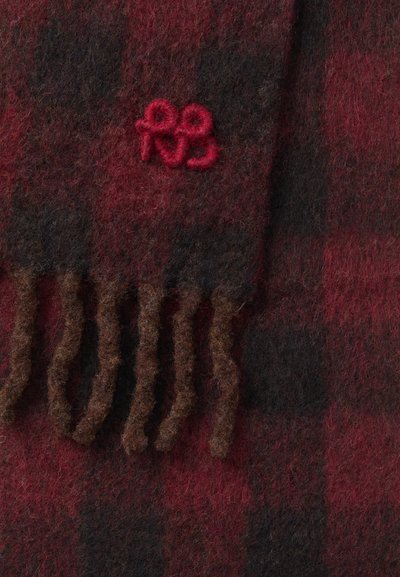 Rødt og sort ternet tørklæde lavet af uld, med frynser i kanten og et lille rødt broderet logo. Blød tekstur, varm udseende.