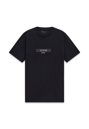 T-shirt nera di cotone con maniche corte, scollo rotondo, con una toppa logo orizzontale con la scritta "GUESS EST. 1981" in bianco e grigio.