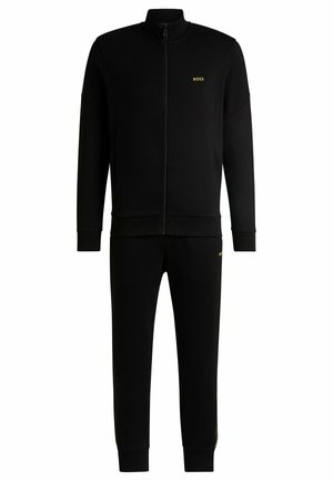 Black tracksuit with zip-up jacket and elastic waistband pants. Features "BOSS" logo in gold on the chest and left leg. Smooth texture.
