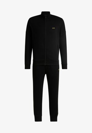 Black tracksuit with zip-up jacket and elastic waistband pants. Features "BOSS" logo in gold on the chest and left leg. Smooth texture.