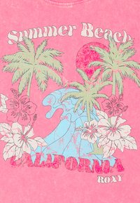 Lyserød bomuld t-shirt med et grafisk design af palmer, en bølge, hibiscusblomster og tekst, der siger "Sommerstrand CALIFORNIA Roxy."