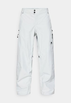 Pantaloni albi de zăpadă din material impermeabil, având două butoane, buzunare laterale cu fermoar, talie ajustabilă și un logo pe partea inferioară a piciorului stâng.