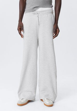 Lys grå wide-leg sweatpants med snor i taljen, lavet af blødt stof. Har en tekstureret overflade og minimalistisk design.