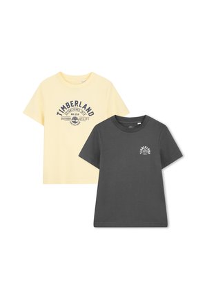 Two T-shirts: one light yellow with a navy logo, the other dark gray with a smaller logo. Both are short-sleeved and made of cotton.