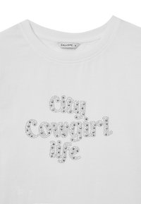 T-shirt bianco con scollo rotondo, caratterizzato dal testo "City Cowgirl Life" in strass argentati di diverse dimensioni e lucentezza.