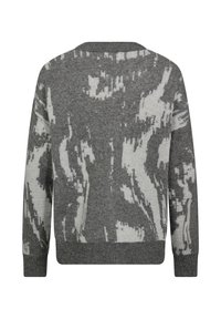 Grå tröja med ett texturerat, abstrakt vitt mönster. Mjuk stickad material, rundad halsringning och ribbad mudd i ärmar och nederkant.