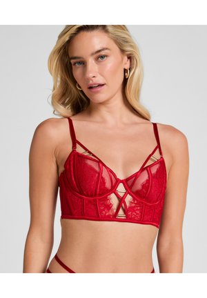 Rode kant bralette met doorschijnende cups, onderbouwsteuning en decoratieve gouden hardware. Beschikt over verstelbare banden en een kruislingse ontwerp.