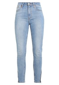 Light blue skinny jeans made of denim, featuring a high waist, front pockets, and zippers at the ankles. Smooth texture and classic design.