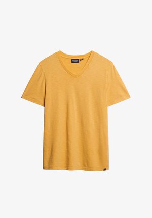 Geel v-hals t-shirt gemaakt van zachte, gestructureerde stof. Korte mouwen en een losse pasvorm. Heeft een klein merklabel aan de onderkant.