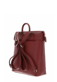 Sac à dos en cuir rouge avec une forme structurée, une poignée supérieure et des bretelles réglables. Comprend un compartiment zippé et quincaillerie en ton argent.