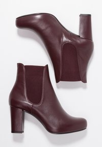 Burgundy leather ankle boots with a smooth surface, elastic side panels, and a chunky block heel. The design features a rounded toe.