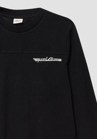Zwarte langarmshirt met de tekst "EEN DAG VERLOREN IN DE NATUUR" in het wit gedrukt op de linkerkant van de borst, met een klein s.Oliver-label binnenin de kraag.