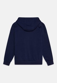 Sötétkék kapucnis pulóver, puha anyagból készült, hosszú ujjú, laza fazonú, bordás mandzsettával és aljjal. Hátsó nézet látható.