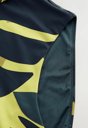 Svetlorjavi material za kopalke v temno modri barvi z abstraktnimi rumenimi in zelenimi listnatimi vzorci. Gladka tekstura s prilegajočim dizajnom in šivanim robom.