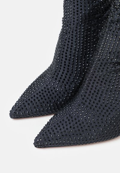Black fabric ankle boots with pointed toes, featuring a textured surface adorned with small rhinestones for added visual detail.