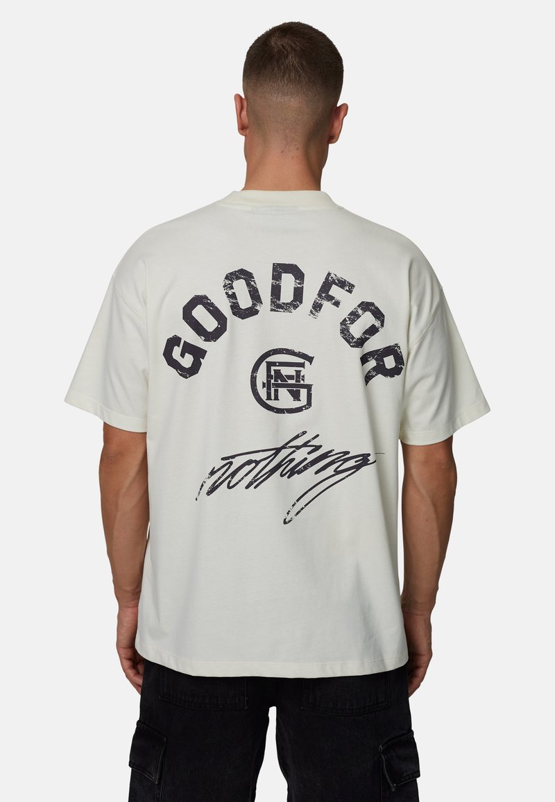 T-shirt en coton blanc avec texte noir "GOOD FOR" au-dessus d'un logo et "nothing" en écriture cursive, coupe décontractée, manches courtes et texture douce.