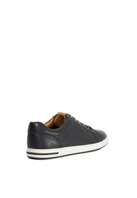 Black leather sneaker with a woven side texture, white rubber sole, brown interior, and six eyelets for laces. Minimalist design.