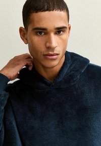 Marineblauwe, gevoerde fleece-pullover met een zachte textuur, met een relaxte pasvorm en een ronde halslijn. Geen zichtbare logo's of patronen.