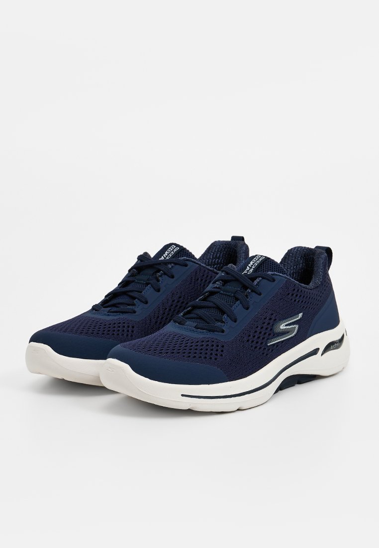 Zapatillas deportivas azul marino con parte superior de malla transpirable, suela blanca, diseño de cordones y un sutil logo en el lateral.