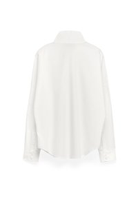 Camicia bianca a maniche lunghe con colletto a punta, orlo arrotondato, polsini con bottoni e una texture liscia, vista dal retro.