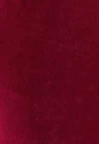 Tela burdeos con una textura suave y tejida, con un patrón ligeramente acanalado en toda la superficie. Cubre toda el área de la imagen.