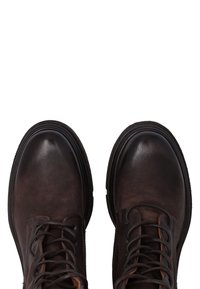 Bottines en cuir marron avec un bout arrondi, un laçage et une surface texturée, dotées d'une semelle en caoutchouc durable pour plus d'adhérence.