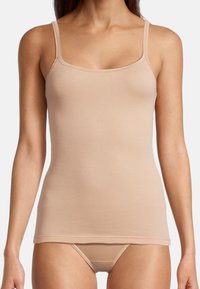 Nude tank top with thin straps, made from smooth, stretchy fabric. Features a fitted design and a straight hem. Suitable for layering.