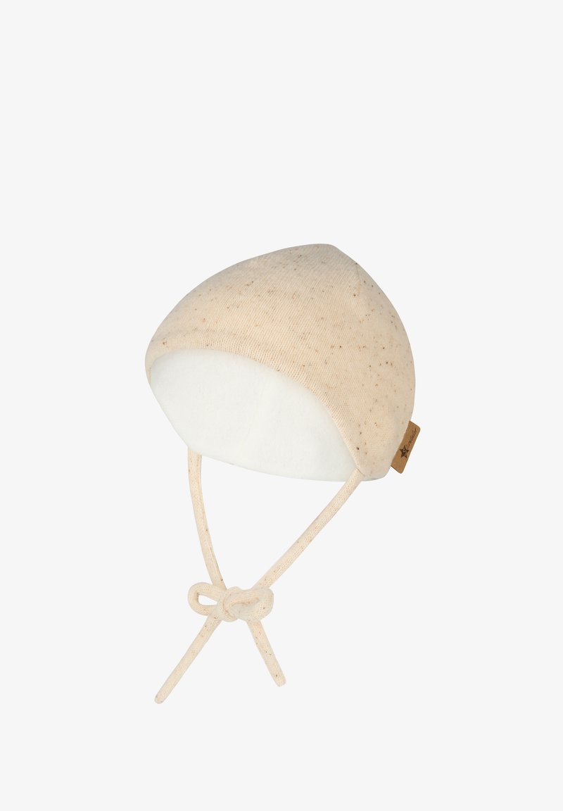 Beige knit baby bonnet with small speckles, soft white lining, and tied straps under the chin.