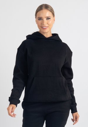 Czarna bluza z kapturem z przednią kieszenią, wykonana z miękkiego materiału. Charakteryzuje się luźnym krojem i prążkowanymi mankietami. Gładka faktura, minimalistyczne wykończenia.