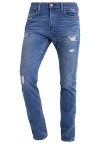 Ljusblå slitna denimjeans med smal benvidd, med olika revor och blekningsdetaljer, samt en standard femficksdesign.